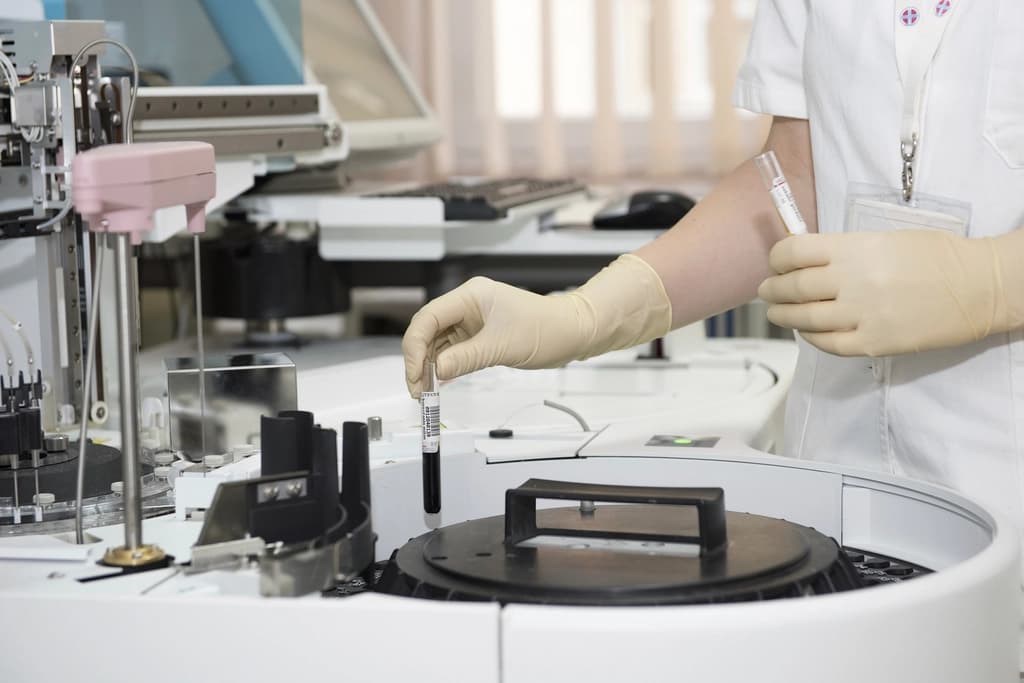 Technician loading a sample into an automated analyser