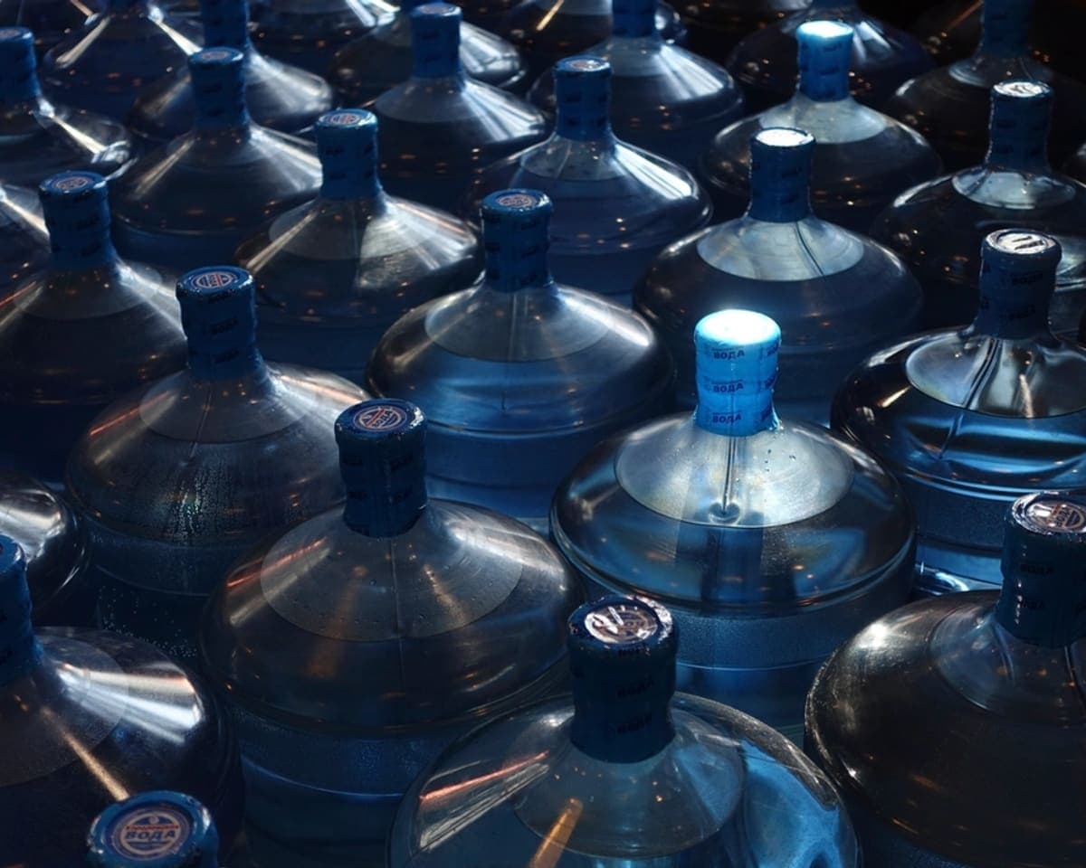 Rows of filled bottled-water carboys at a water plant