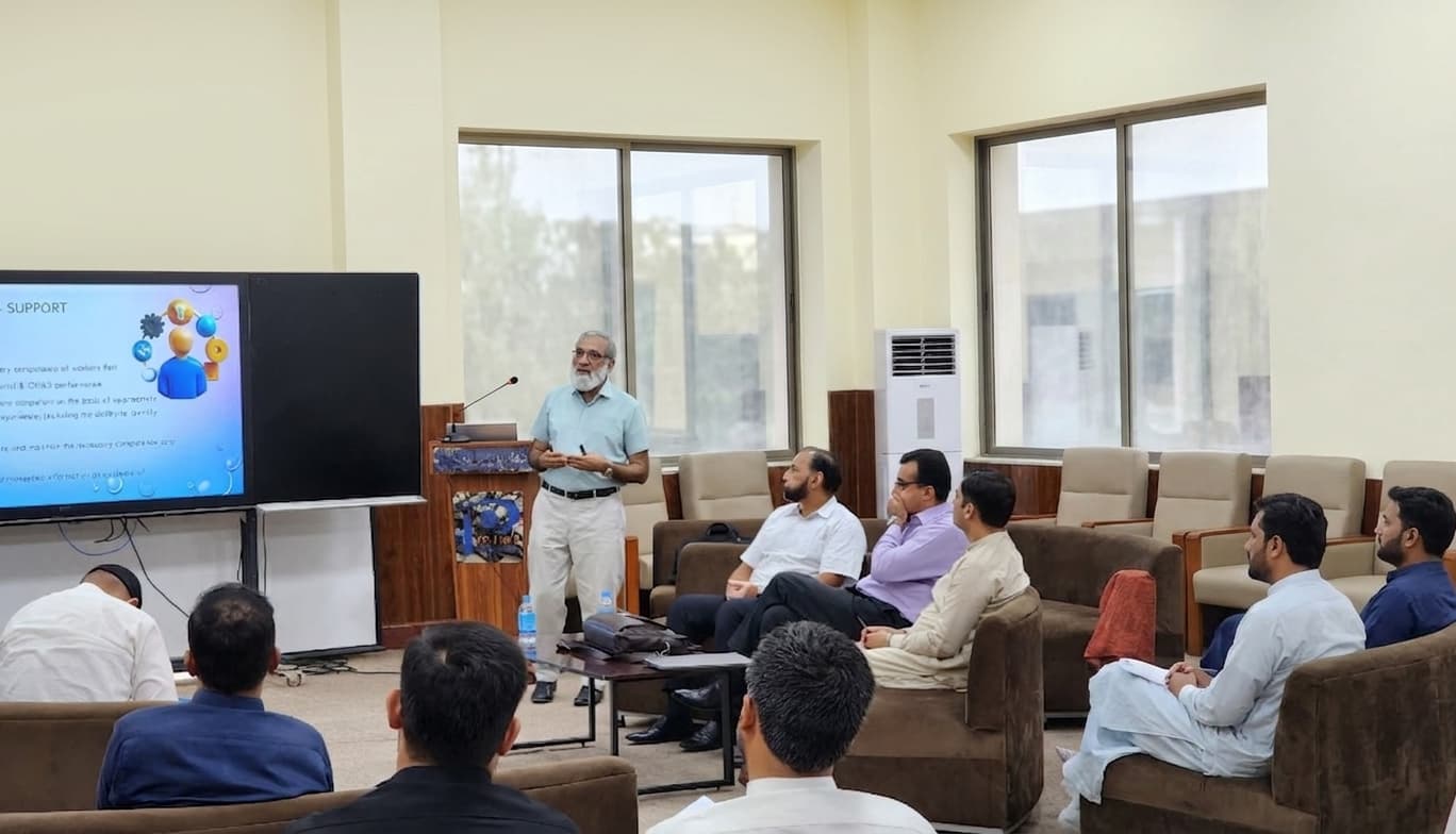 Instructor presenting to a seated audience in a training room